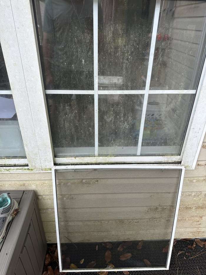 Window covered in grime with the screen removed, before cleaning